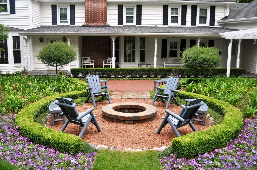 Brick walkways and a brick patio work in concert with boxwood and yew hedges on this farmhouse landscape.

A fire pit, Adirondack furniture and plenty of annual flowers are also woven into the fabric of this landscape design. by KD Landscape | Fire Pits|Backyard Design|Outdoor Living Spaces|Landscape Design|Backyard Ideas|Landscaping|Landscaping Ideas|Landscape Installation|Fire Feautures|Fire Pit
