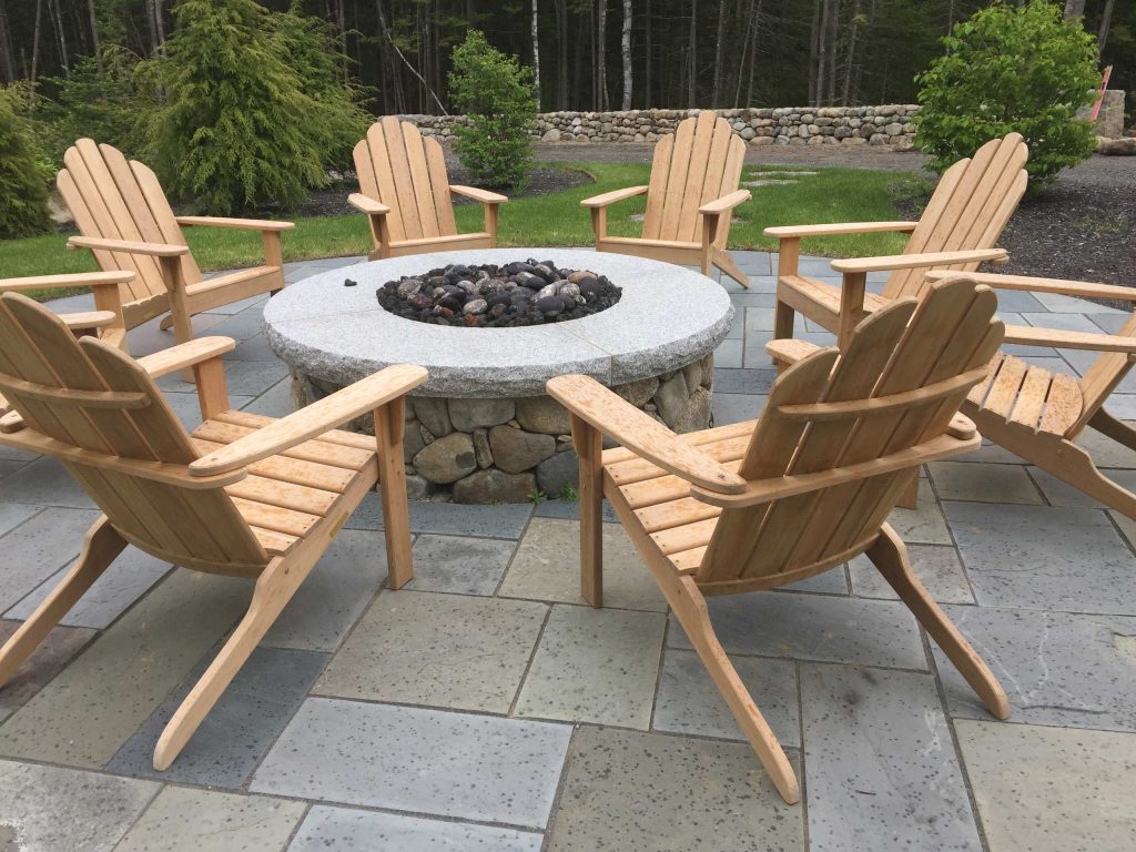 natural stone firepit with thermaled granite capstones. Square-rectangular bluestone terrace
