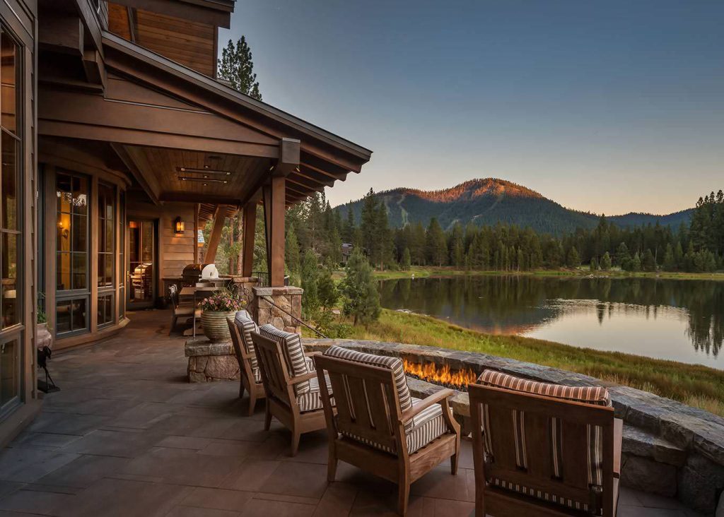 Example of a mountain style deck design in Sacramento with a fire pit and a roof extension