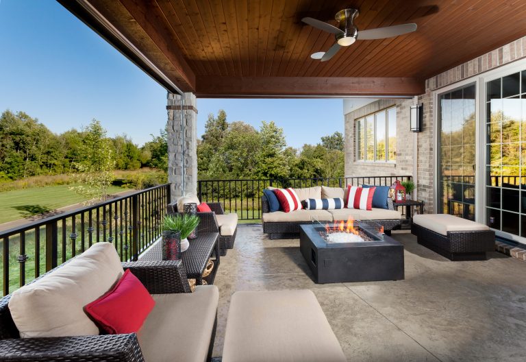 This is an example of a large transitional concrete paver back porch design in Detroit with a fire pit and a roof extension.