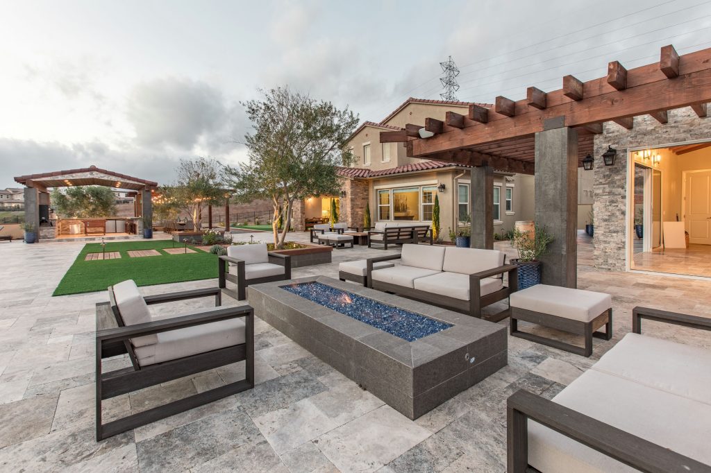 Large trendy backyard stone patio photo in San Diego with a fire pit and a pergola