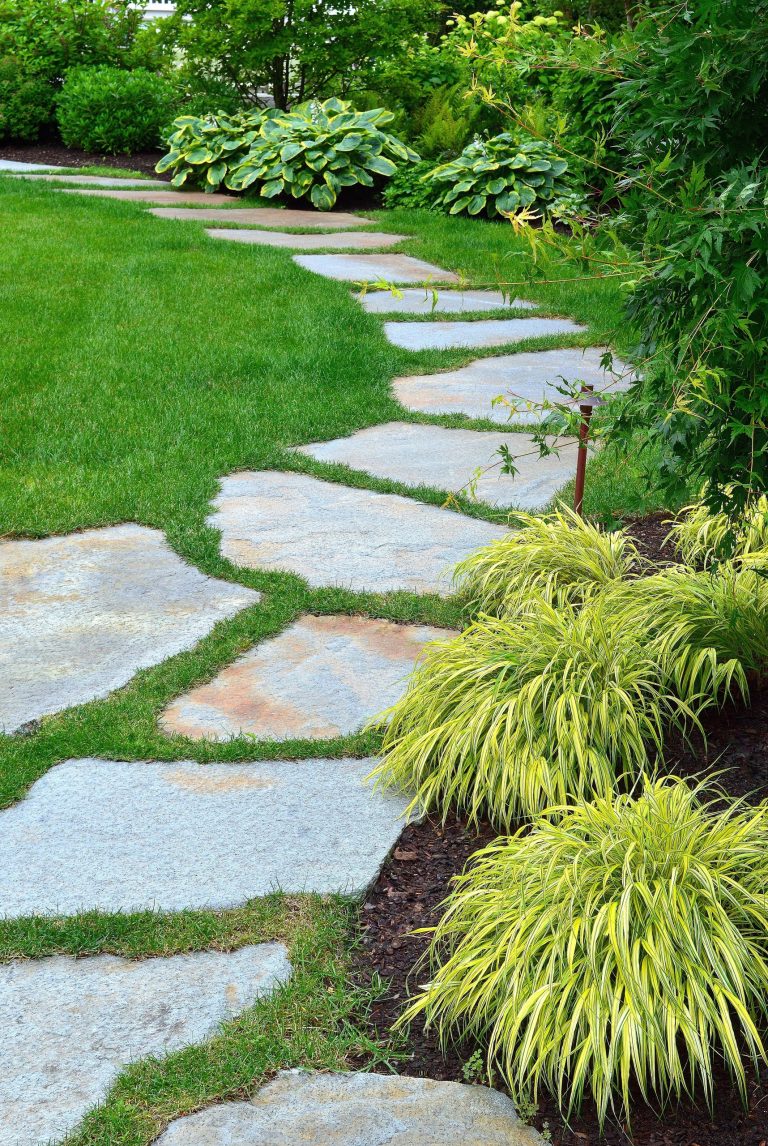 Andover, MA backyard renovation. - Bluestone patio with radius cut curved stone accents. New England fieldstone seat wall, fire pit and Goshen stone pavers leading to pool house. Granite paver borders and jumbo granite cobbled apron on driveway with lavender and misc. plantings - Sallie Hill Design | Landscape Architecture | 339-970-9058 | salliehilldesign.com | photo ©2012 Brian Hill
