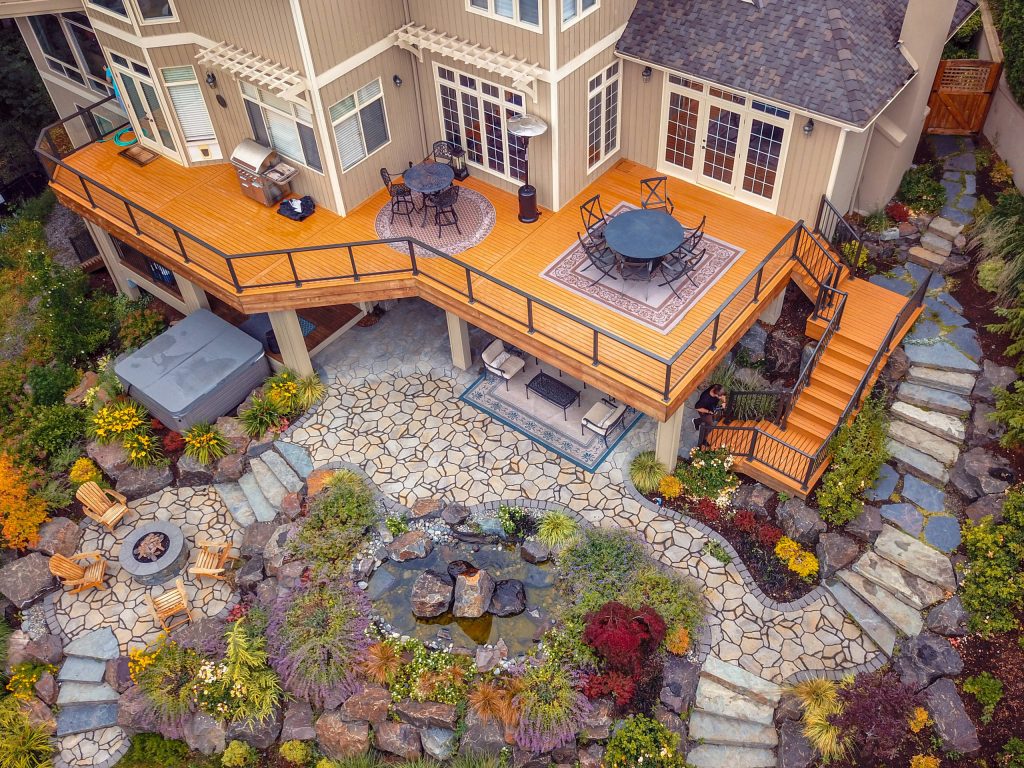 Second level cedar deck with aluminum railing and beautiful landscaping. This project has an under deck ceiling under a portion of the deck to keep it dry year-round. This project also includes a fire pit and hot tub.