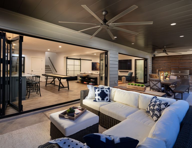 Two large panoramic doors forge an immediate connection between the interior and exterior spaces and instantly doubles our client’s entertaining space. A stunning combination of covered and uncovered outdoor rooms include a dining area with ample seating conveniently located near the custom stacked stone outdoor kitchen and prep area with sleek concrete countertops, privacy screen walls and high-end appliances. The designated TV/lounge area offers additional covered seating and is the perfect spot for relaxing or watching your favorite movie or sports team.