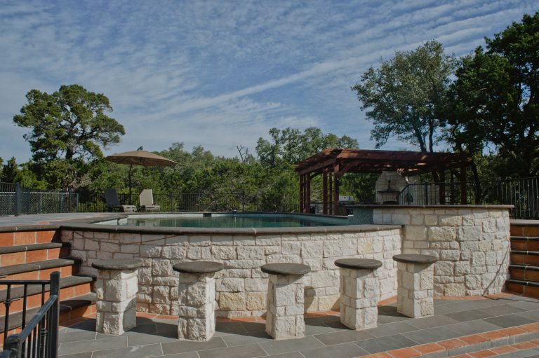 This hill country home has several outdoor living spaces including this above ground swimming pool.

The stone flooring is 12x24 Cantera stone tile in Recinto color. It is accented with 6x12 Antique Saltillo tile - also known as antique terra cotta tile. The barstools are also topped with custom fit cantera stone seating.

The coping edges are also Cantera stone coping pieces in Recinto. This is similar to a volcanic rock.

Drive up to practical luxury in this Hill Country Spanish Style home. The home is a classic hacienda architecture layout. It features 5 bedrooms, 2 outdoor living areas, and plenty of land to roam.

Classic materials used include:
Saltillo Tile - also known as terracotta tile, Spanish tile, Mexican tile, or Quarry tile
Cantera Stone - feature in Pinon, Tobacco Brown and Recinto colors
Copper sinks and copper sconce lighting
Travertine Flooring
Cantera Stone tile
Brick Pavers

Photos Provided by
April Mae Creative
aprilmaecreative.com

Tile provided by Rustico Tile and Stone - RusticoTile.com or call (512) 260-9111 / info@rusticotile.com

Construction by MelRay Corporation by Rustico Tile & Stone | Pool design | Pool Contracting | Swimming Pool Ideas | Swimming Pool Design Ideas