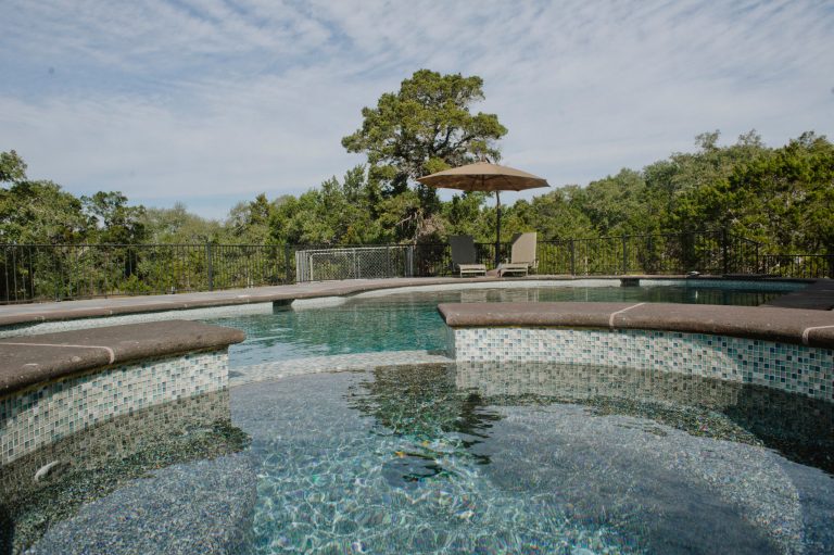 It's not a spanish style home without a free form pool and hot tub for relaxing on hot summer days.

The stone flooring is 12x24 Cantera stone tile in Recinto color. It is accented with 6x12 Antique Saltillo tile - also known as antique terra cotta tile. The barstools are also topped with custom fit cantera stone seating.

The coping edges are also Cantera stone coping pieces in Recinto. This is similar to a volcanic rock.

Drive up to practical luxury in this Hill Country Spanish Style home. The home is a classic hacienda architecture layout. It features 5 bedrooms, 2 outdoor living areas, and plenty of land to roam.

Classic materials used include:
Saltillo Tile - also known as terracotta tile, Spanish tile, Mexican tile, or Quarry tile
Cantera Stone - feature in Pinon, Tobacco Brown and Recinto colors
Copper sinks and copper sconce lighting
Travertine Flooring
Cantera Stone tile
Brick Pavers

Photos Provided by
April Mae Creative
aprilmaecreative.com

Tile provided by Rustico Tile and Stone - RusticoTile.com or call (512) 260-9111 / info@rusticotile.com

Construction by MelRay Corporation by Rustico Tile & Stone | Pool design | Pool Contracting | Swimming Pool Ideas | Swimming Pool Design Ideas