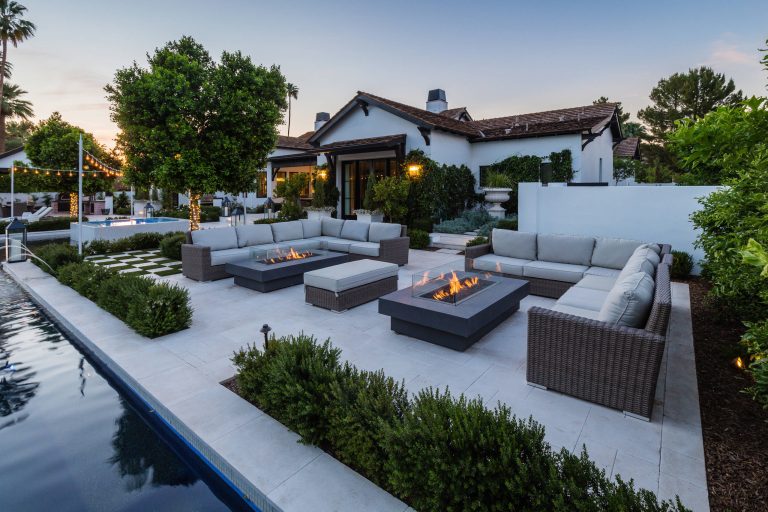 Example of a country patio design in Phoenix with a fire pit and no cover