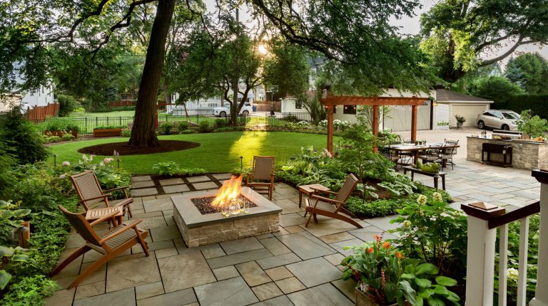 Large elegant backyard stone patio photo with a fire pit