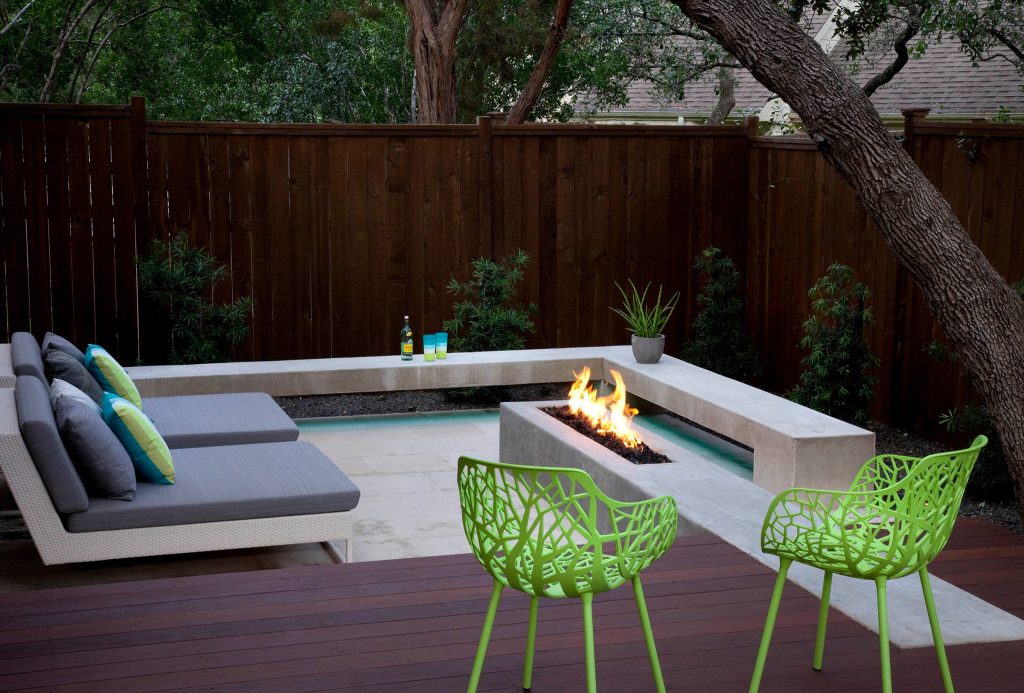 a concrete fire pit with black lava rock surrounded by built-in concrete seating and comfortable chaise lounges perfect for relaxing or entertaining


designed & built by austin outdoor design
photo by ryann ford by austin outdoor design | Fire Pits|Backyard Design|Outdoor Living Spaces|Landscape Design|Backyard Ideas|Landscaping|Landscaping Ideas|Landscape Installation|Fire Feautures|Fire Pit