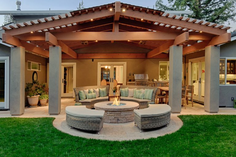 The homeowners desired an outdoor space that felt more rustic than their refined interior spaces, but still related architecturally to their house. Cement plaster support arbor columns provide enough of visual tie to the existing house exterior. Oversized wood beams and rafter members provide a unique outdoor atmosphere. Structural bolts and hardware were minimized for a cleaner appearance. Structural connections and supports were engineered to meet California's stringent earthquake standards.

Ali Atri Photography by Kikuchi + Kankel Design Group | Fire Pits|Backyard Design|Outdoor Living Spaces|Landscape Design|Backyard Ideas|Landscaping|Landscaping Ideas|Landscape Installation|Fire Feautures|Fire Pit