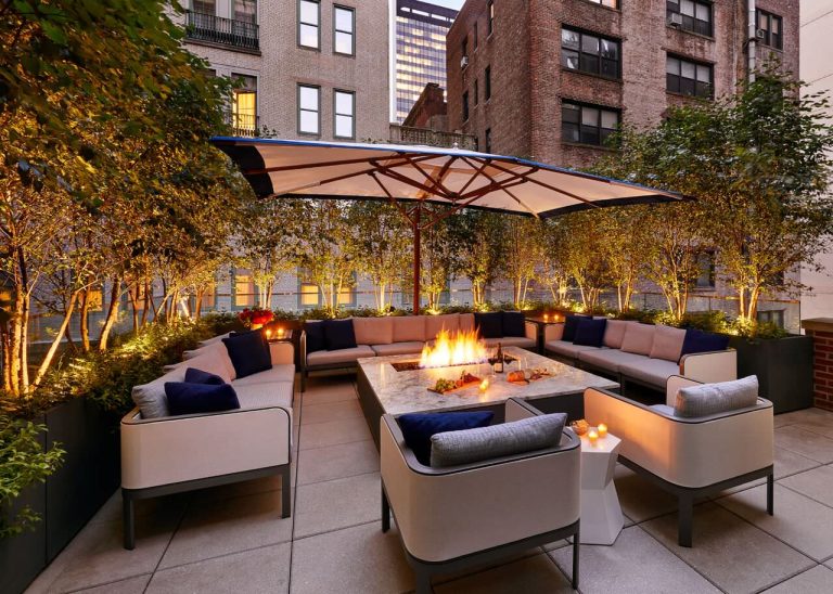 Example of a transitional concrete paver patio design in New York with a fire pit and no cover