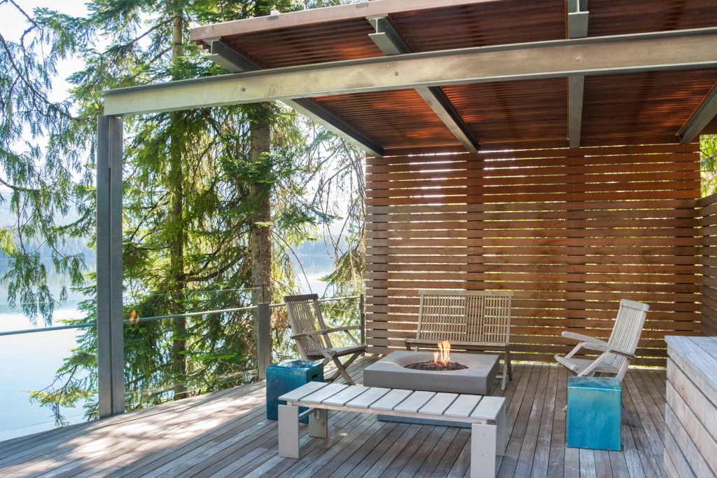 Mid-sized trendy backyard deck photo in Seattle with a fire pit and an awning