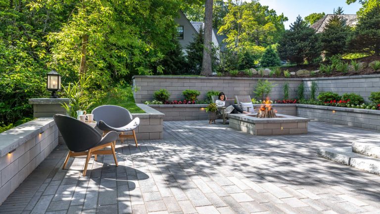 These homeowners faced a significant challenge when designing the patio of their dreams. The yard sloped into a forest backing onto their home. This was resolved by building several steps that lead to a beautiful sunken patio with a surrounding U-Cara retaining wall that showcases their lush gardens. They chose to also add a U-Cara firepit as the focal point, so their family can relax in a cozy setting.