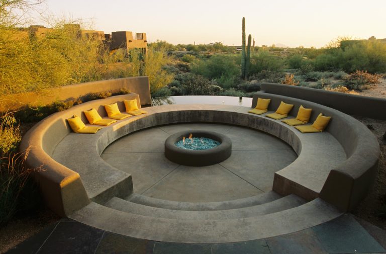 Example of a tuscan concrete patio design in Phoenix with a fire pit and no cover