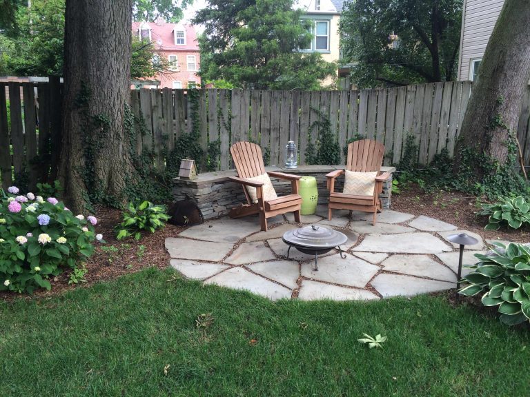 Example of a large classic backyard stone patio design in Philadelphia with a fire pit and no cover