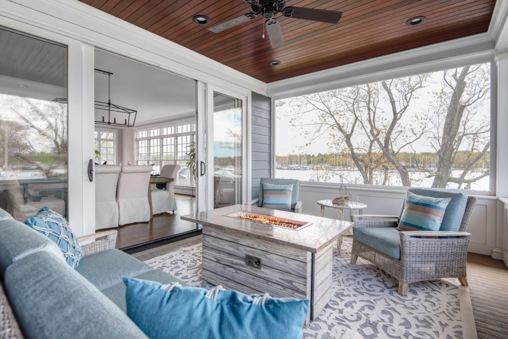 Beach style porch idea in DC Metro with a fire pit, decking and a roof extension