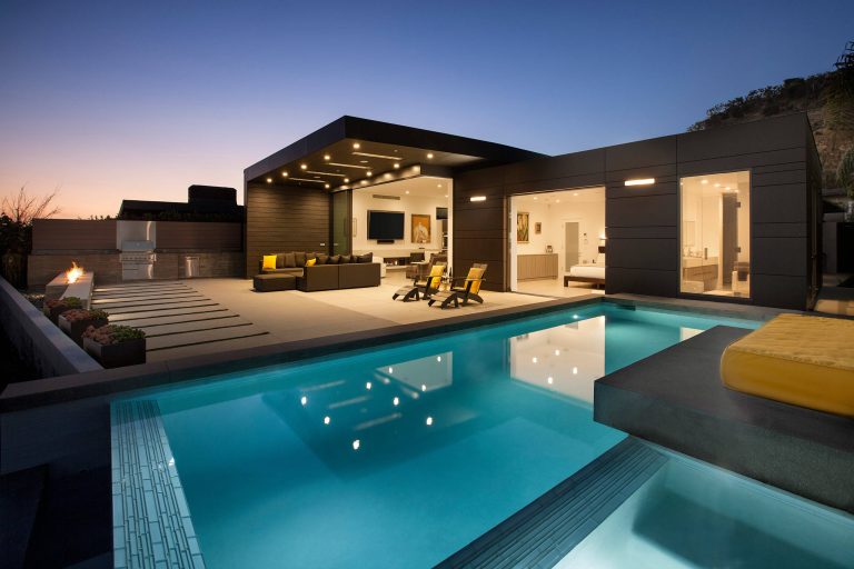 The back of the home opens up both visually and physically to create an indoor/outdoor environment.

Photo: Jim BartschExample of a mid-sized trendy backyard concrete paver and rectangular infinity hot tub design in Los Angeles by Abramson Architects | Pool design | Pool Contracting | Swimming Pool Ideas | Swimming Pool Design Ideas