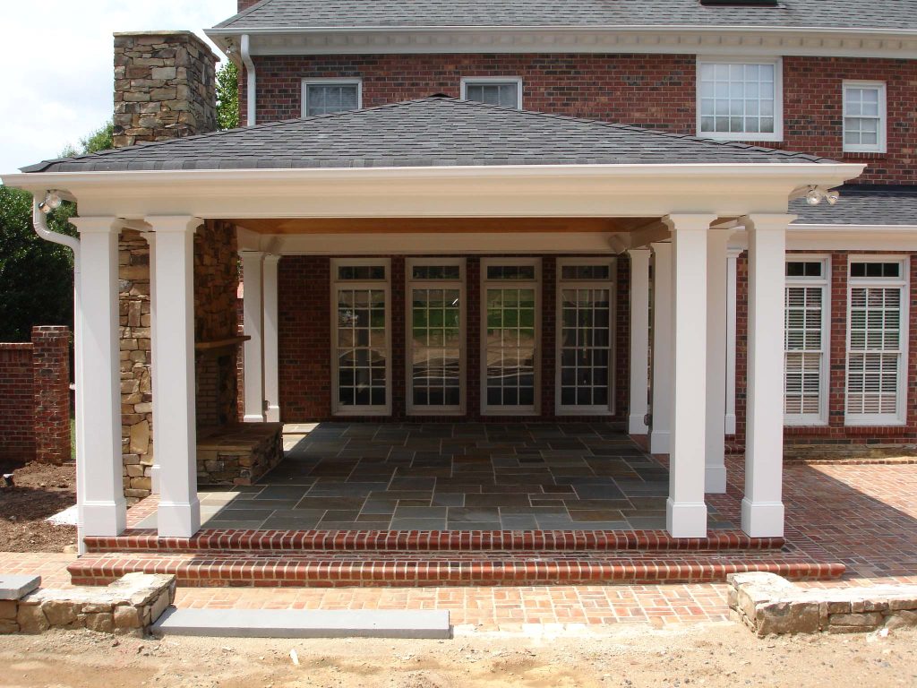 outdoor fireplace with a covered porch and a blue stone patio floor