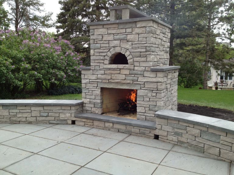 This is an outdoor stone fireplace and Pizza oven built with a unique over/under design. In St. Louis Park, MN By English Stone