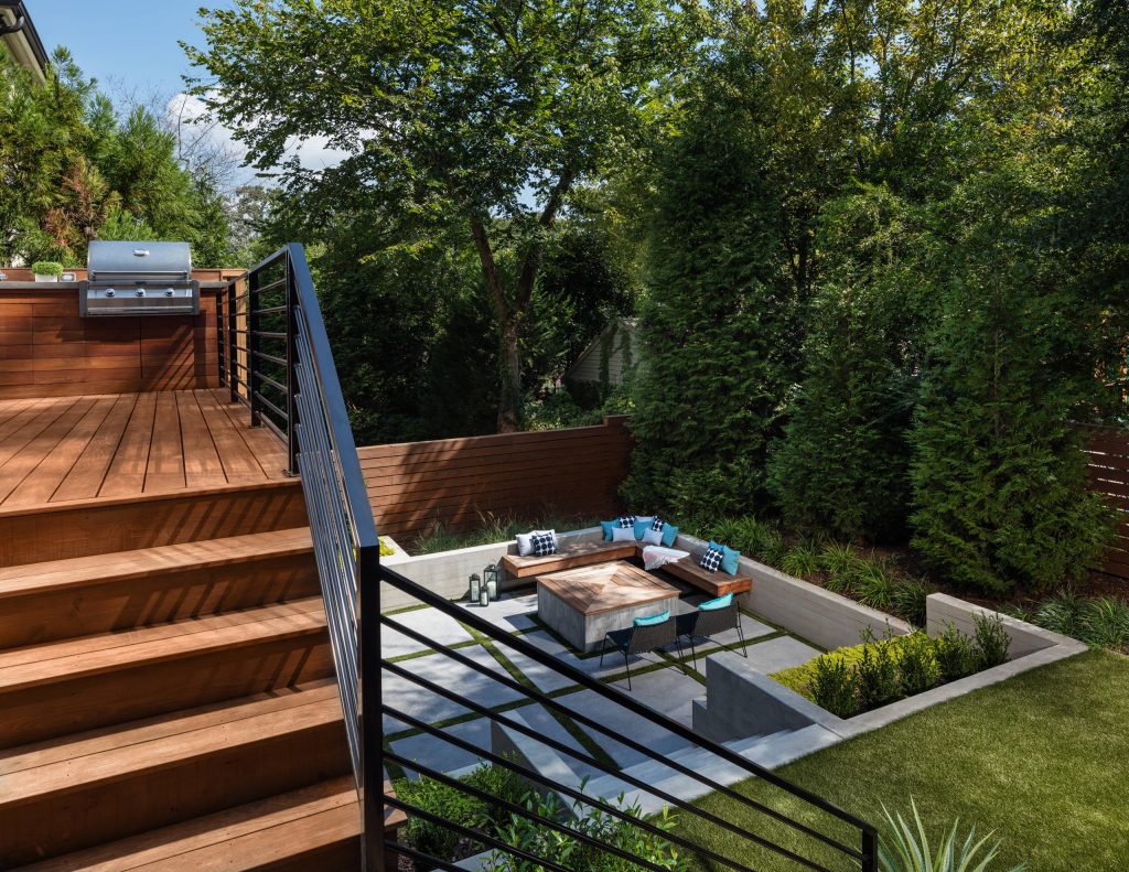 The upper deck includes Ipe flooring, an outdoor kitchen with concrete countertops, and panoramic doors that provide instant indoor/outdoor living. Waterfall steps lead to the lower deck's artificial turf area. The ground level features custom concrete pavers, fire pit, open framed pergola with day bed and under decking system. by Boyce Design and Contracting | Outdoor Photos | Porch | Landscaping | Landscape Design | Outdoor Living Space | Porch Design Ideas | Outdoor Living Space Ideas | Backyard Design