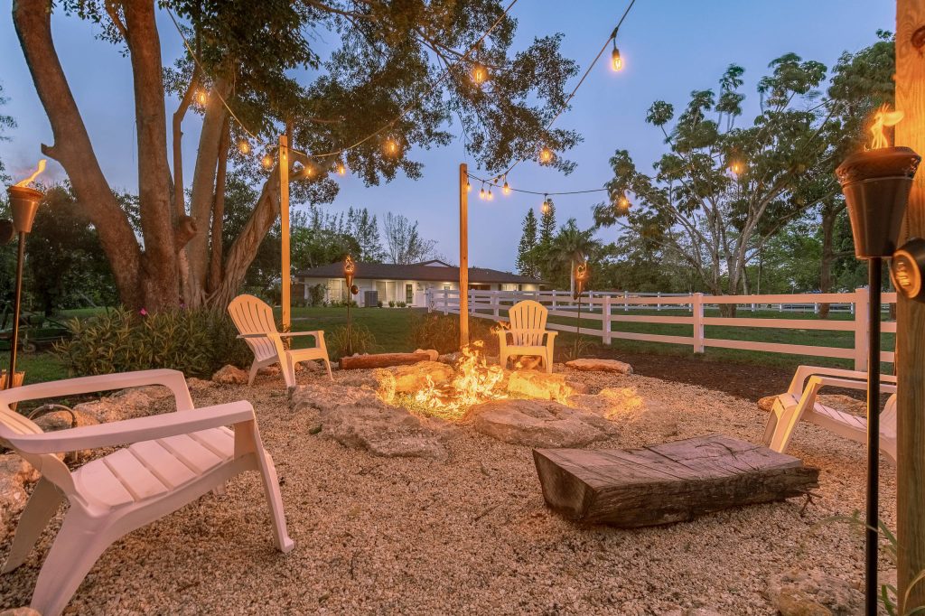 Inspiration for a farmhouse gravel landscaping in Miami with a fire pit.