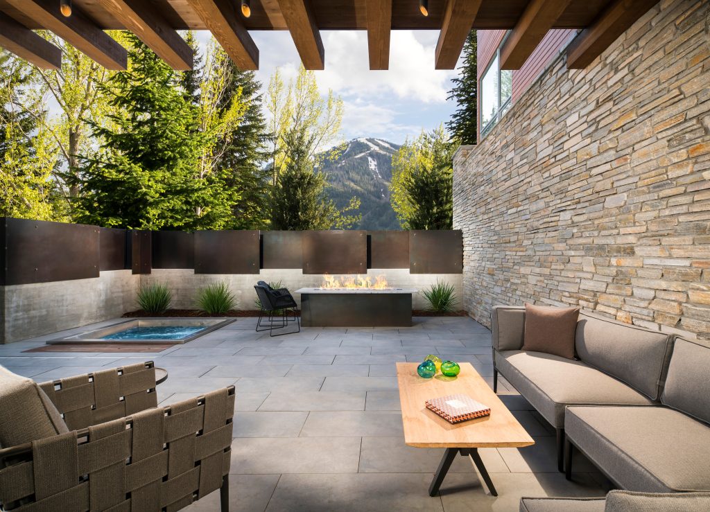 Patio - large rustic side yard concrete paver patio idea in Salt Lake City with a fire pit and a roof extension