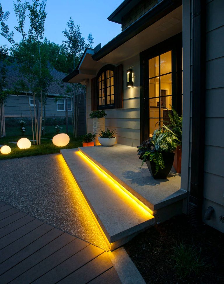 Ipe decking, Earthworks EW Gold Stone decking, and exposed aggregate concrete create a beautiful contrast and balance that give this outdoor architecture design a Frank Lloyd Wright feel. Ipe decking is one of the finest quality wood materials for luxury outdoor projects. The exotic wood originates from South America. This environment contains a fire pit, with cobblestone laid underneath. Shallow, regress lighting is underneath each step and the fire feature to illuminate the elevation change. The bench seating is fabricated stone that was honed to a beautiful finish. This project also features an outdoor kitchen to cater to family or guests and create a total outdoor living experience. by Nature's Touch | Fire Pits|Backyard Design|Outdoor Living Spaces|Landscape Design|Backyard Ideas|Landscaping|Landscaping Ideas|Landscape Installation|Fire Feautures|Fire Pit