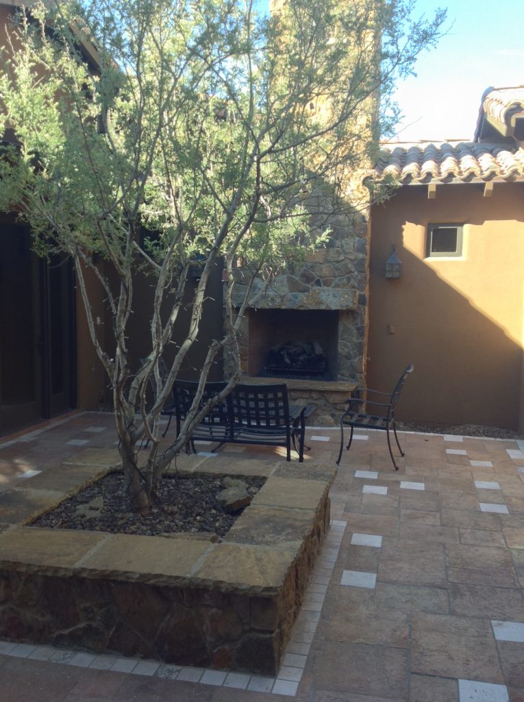 private unique front courtyard, outside fireplace, stone planter