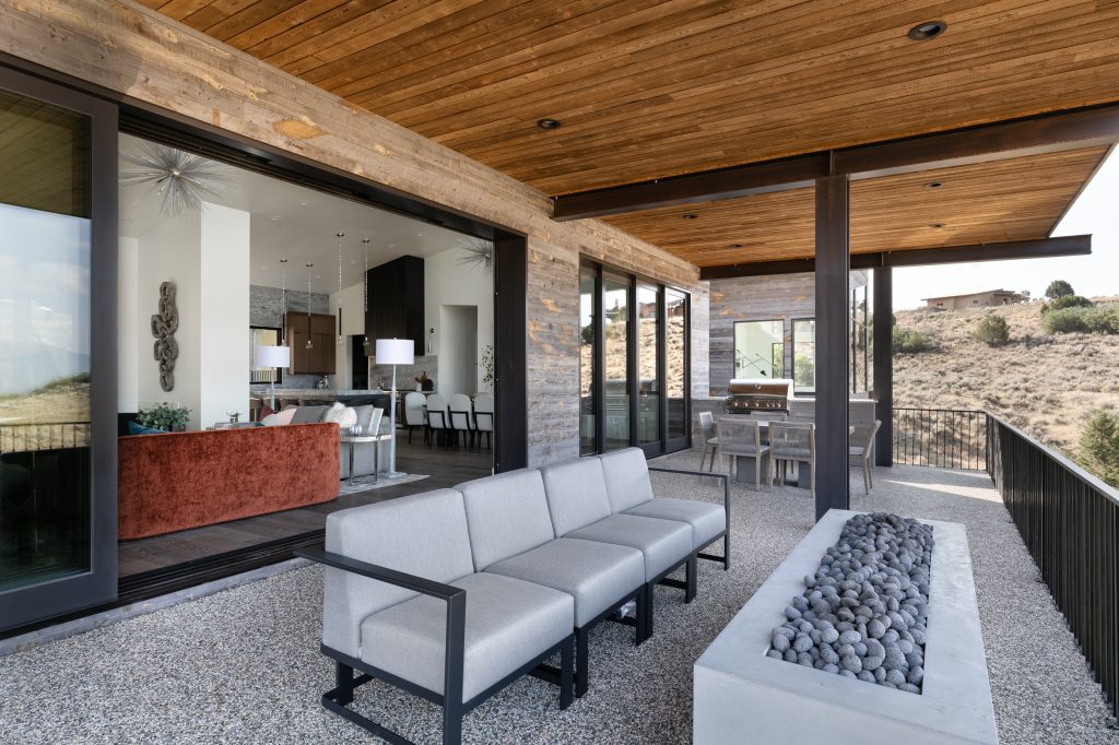 Trendy backyard gravel patio photo in Salt Lake City with a fire pit and a roof extension