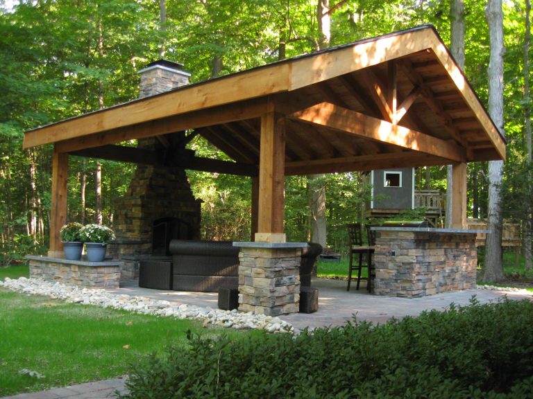 Example of a large mountain style backyard brick patio design in Other with a fire pit and a pergola