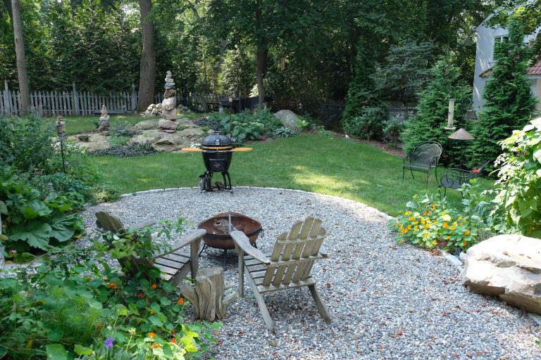 The goal of this landscape design and build project was to create a simple patio using peastone with a granite cobble edging. The patio sits adjacent to the residence and is bordered by lawn, vegetable garden beds, and a cairn rock water feature. Designed and built by Skyline Landscapes, LLC.