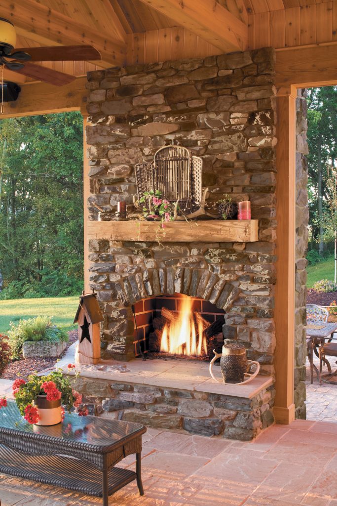 Inspiration for a rustic backyard stone patio remodel in San Diego with a fire pit and a roof extension