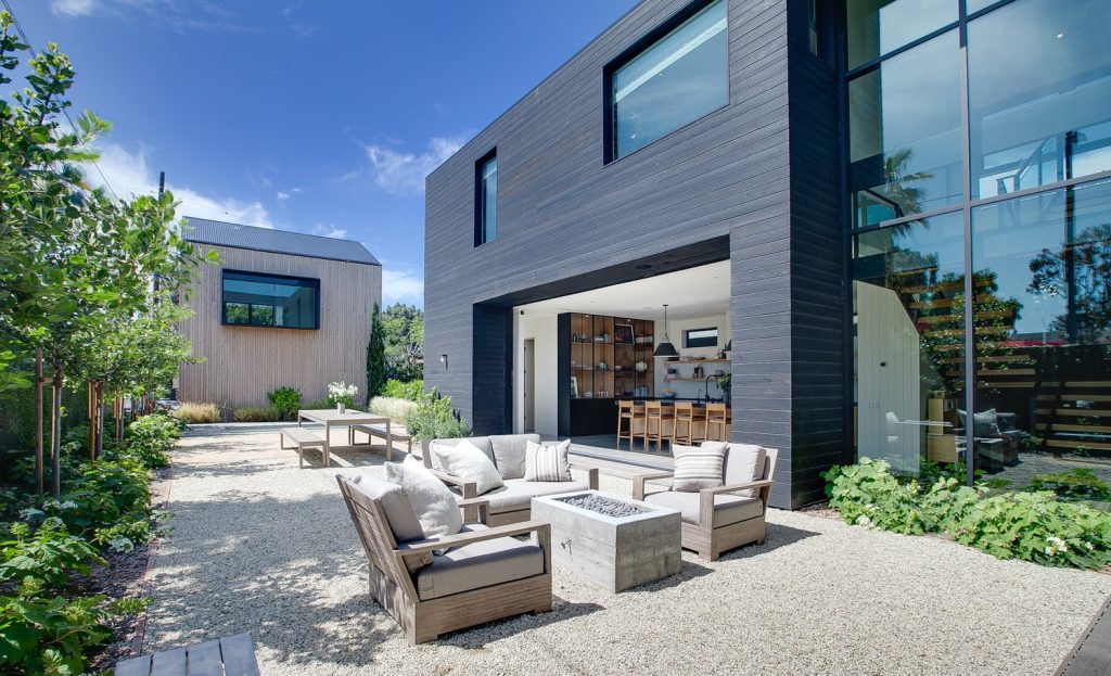 Example of a trendy backyard gravel patio design in Los Angeles with a fire pit and no cover