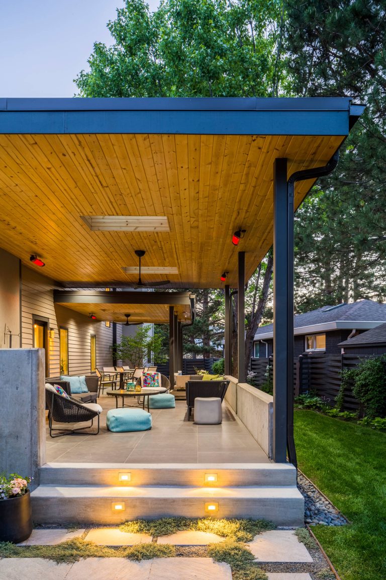 Modern outdoor patio expansion. Indoor-Outdoor Living and Dining. Poured concrete walls, steel posts, bluestain pine ceilings, skylights, standing seam metal roof, firepit, and modern landscaping. Photo by Jess Blackwell