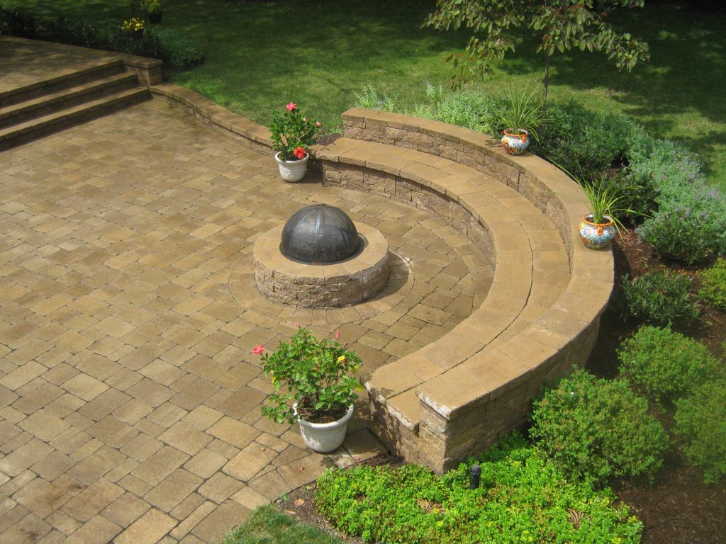 Example of a mid-sized classic backyard brick patio design in New York with a fire pit and no cover