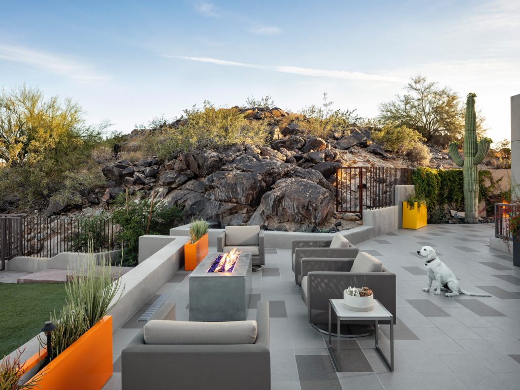 Example of a southwest patio design in Phoenix with a fire pit and no cover