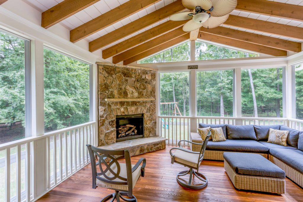 Example of a large classic backyard deck design in Charlotte with a fire pit and a roof extension