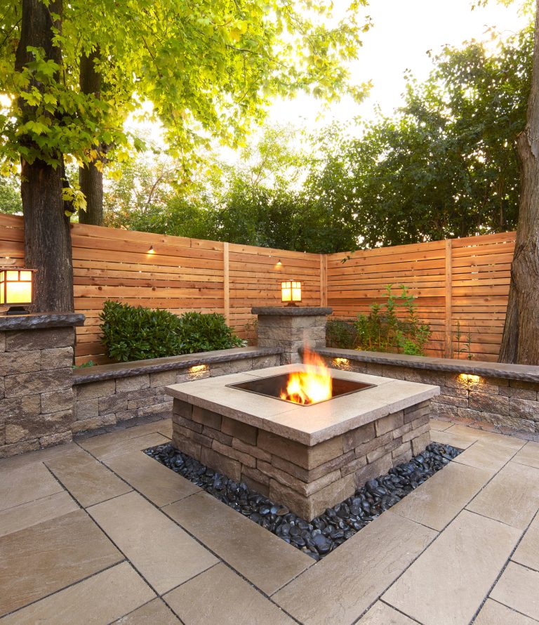 Example of a mid-sized classic backyard stone patio design in New York with a fire pit and no cover
