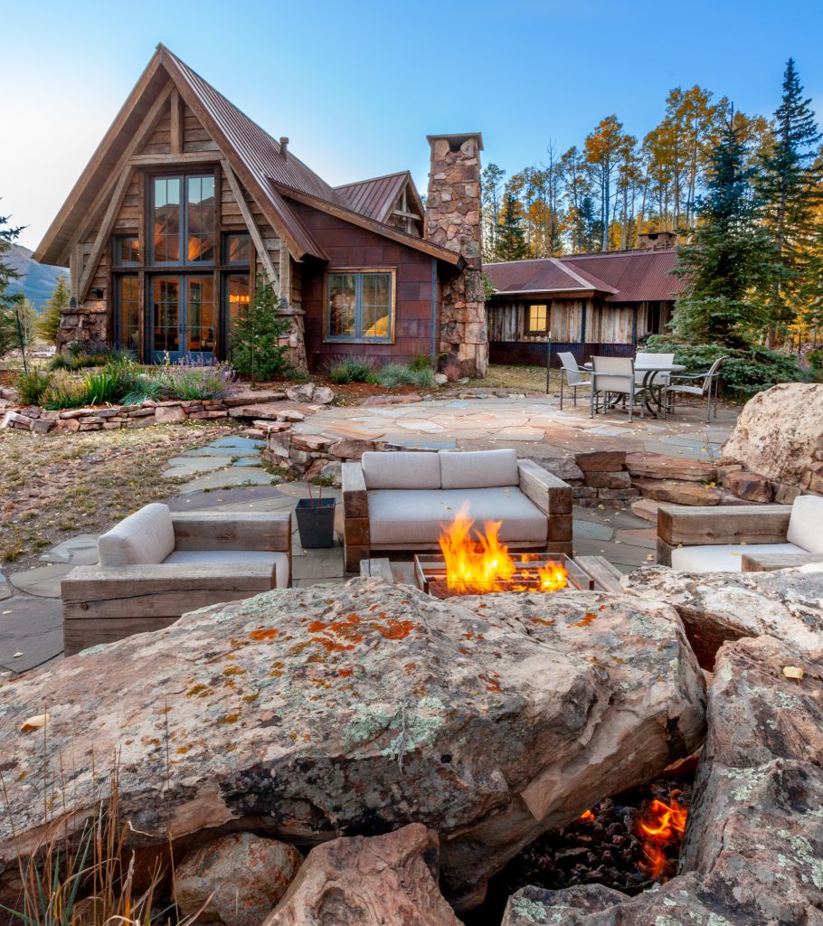 Huge mountain style backyard stone patio photo in Denver with a fire pit and no cover