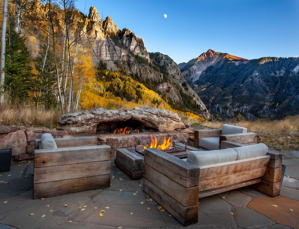 Huge mountain style backyard stone patio photo in Denver with no cover and a fire pit