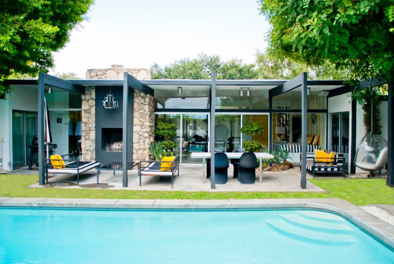 Example of a small 1960s backyard patio design in Los Angeles with a fire pit and a roof extension