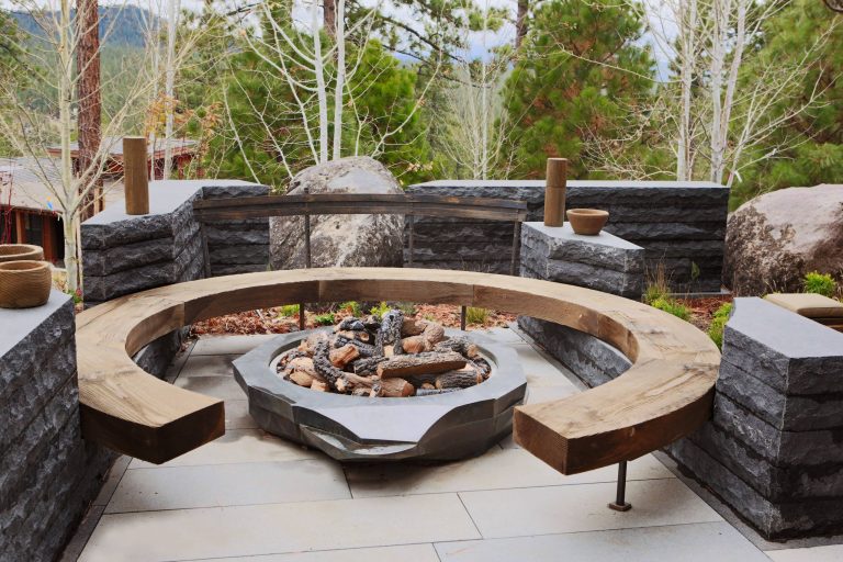 Example of a mid-sized trendy side yard stone patio design in Other with a fire pit and no cover