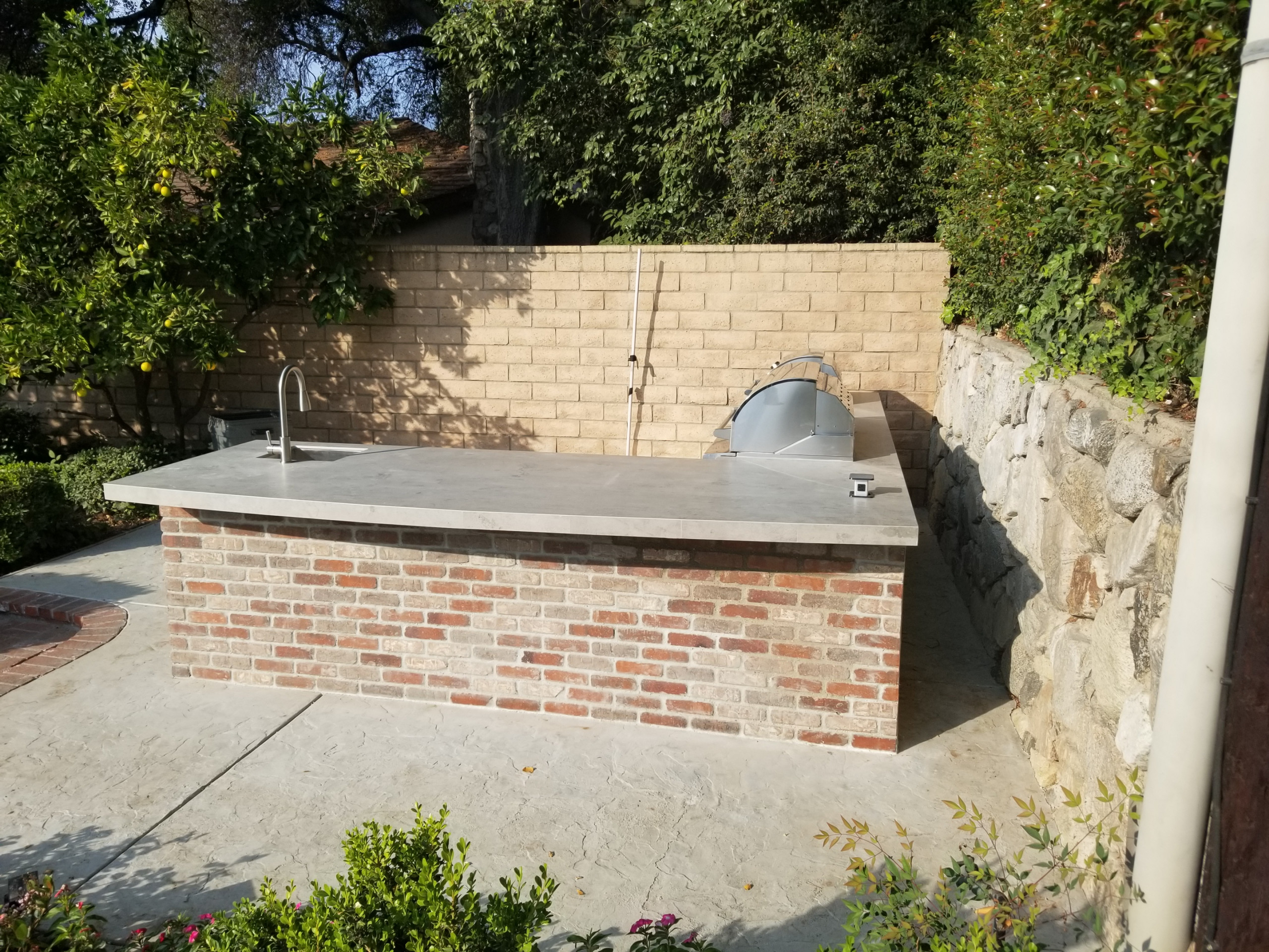 traditional L-shaped island
Example of a classic backyard patio kitchen design in Los Angeles