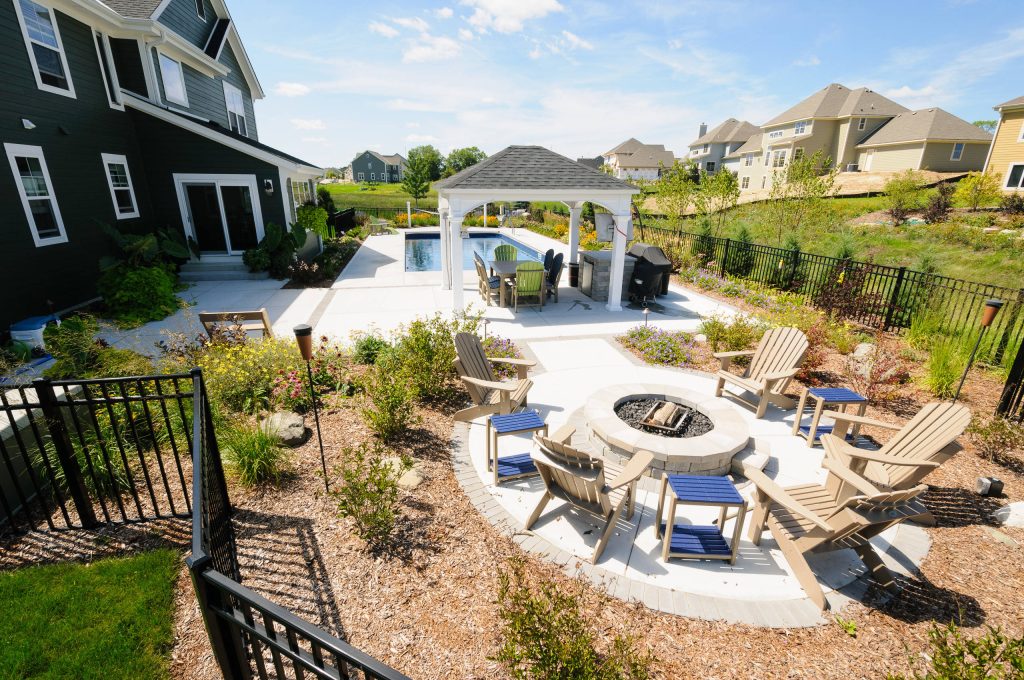 This is an example of a mid-sized traditional full sun backyard concrete paver landscaping in Milwaukee with a fire pit for summer.