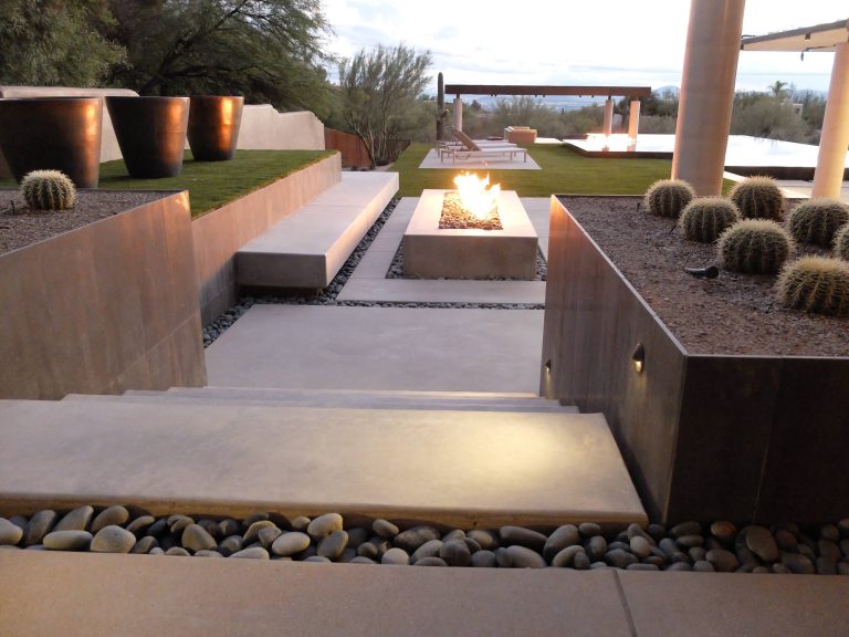 These clients decided to make this home their Catalina Mountain homestead, after living abroad for many years. The prior yard enclosed only a small portion of their available property, and a wall obstructed their city lights view of northern Tucson. We expanded the yard outward to take advantage of the space and to also integrate the topography change into a 360 vanishing edge pool.

The home previously had log columns in keeping with a territorial motif. To bring it up to date, concrete cylindrical columns were put in their place, which allowed us to expand the shaded locations throughout the yard in an updated way, as seen by the new retractable canvas shade structures.

Constructed by Mike Rowland, you can see how well he pulled off the projects precise detailing of Bianchi's Design. Note the cantilevered concrete steps, the slot of fire in the midst of the spa, the stair treads that don't quite touch the adjacent walls, and the columns that float just above the pool water. by Bianchi Design | Fire Pits|Backyard Design|Outdoor Living Spaces|Landscape Design|Backyard Ideas|Landscaping|Landscaping Ideas|Landscape Installation|Fire Feautures|Fire Pit